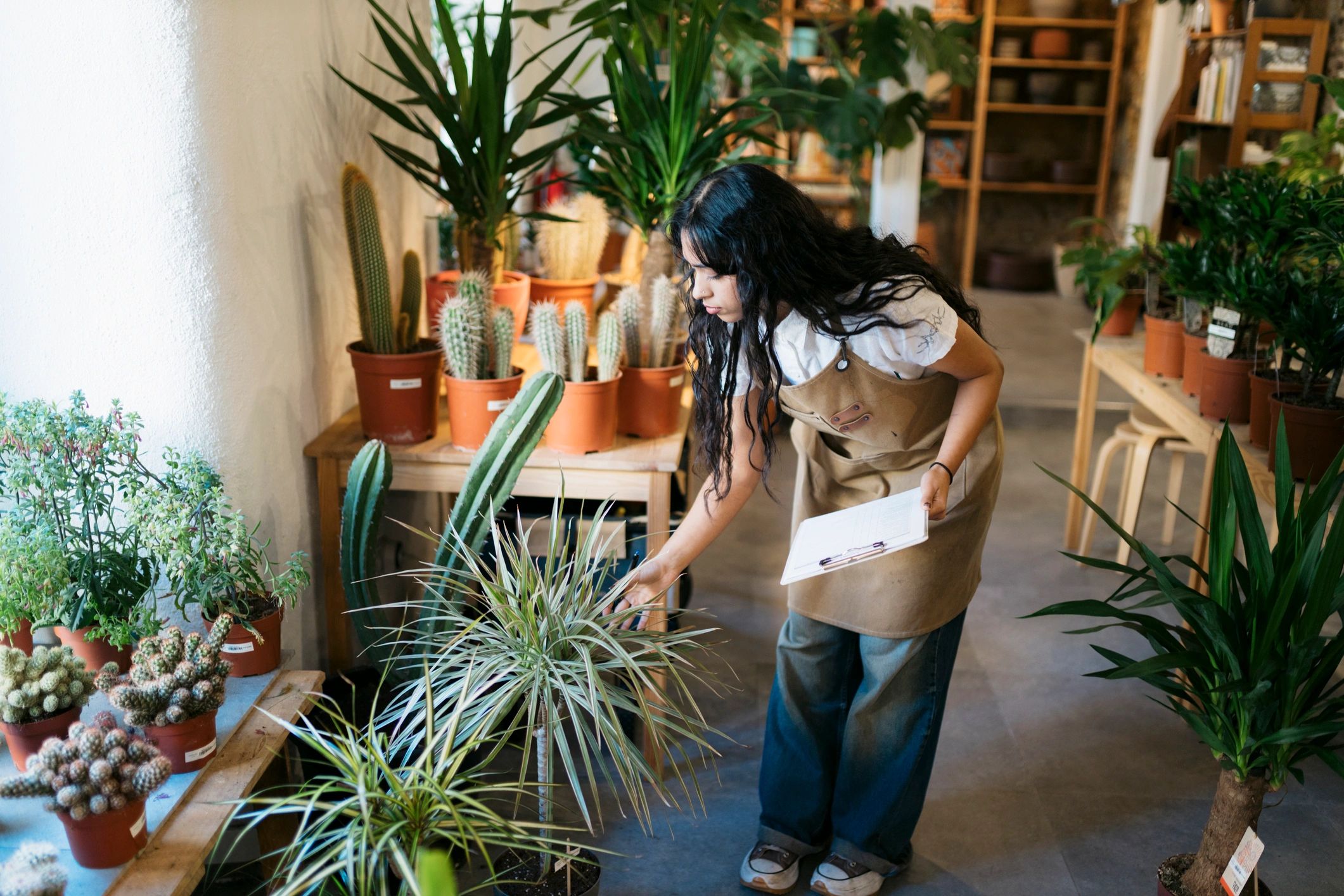 Florist in a shop reviewing notes with flowers nearby